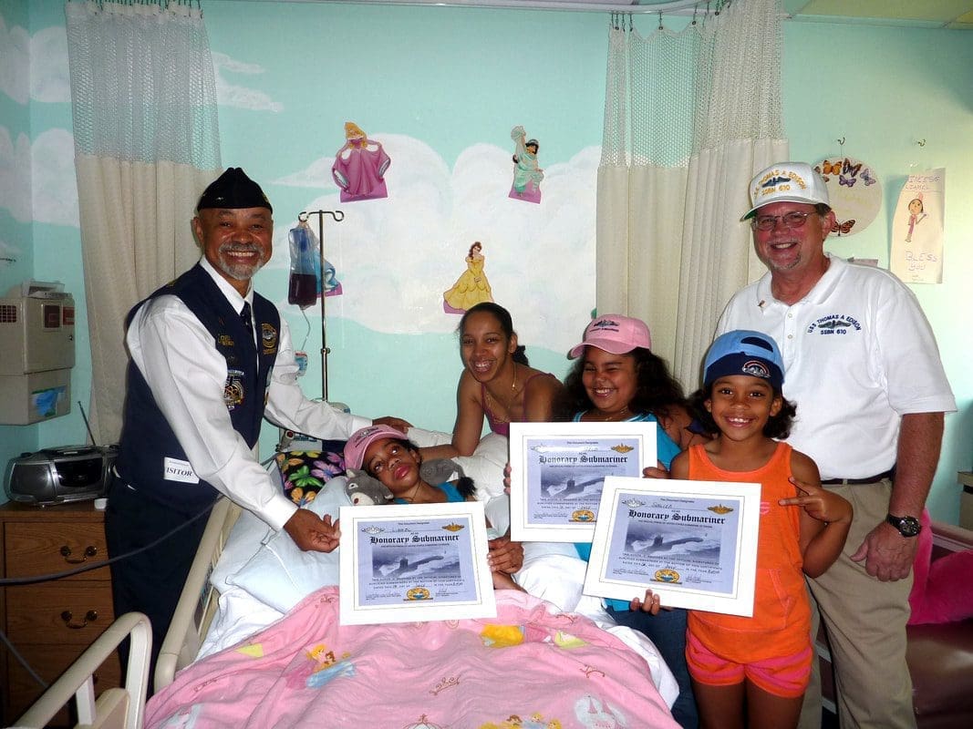 Hospital visit with children holding certificates.