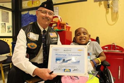 Veteran and child with honorary certificate.
